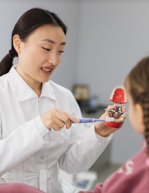 side view of young pretty asian pediatric dentist 2023 11 27 05 19 53 utc 1 1 scaled